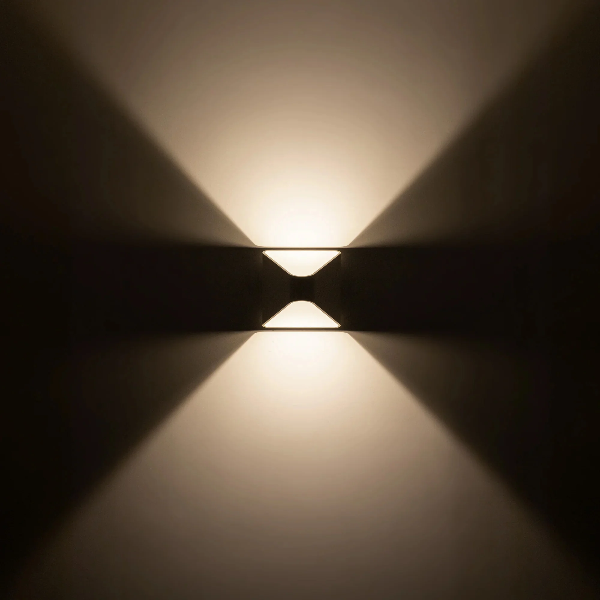Ellis centered between the upward and downward fans of light it casts on the wall